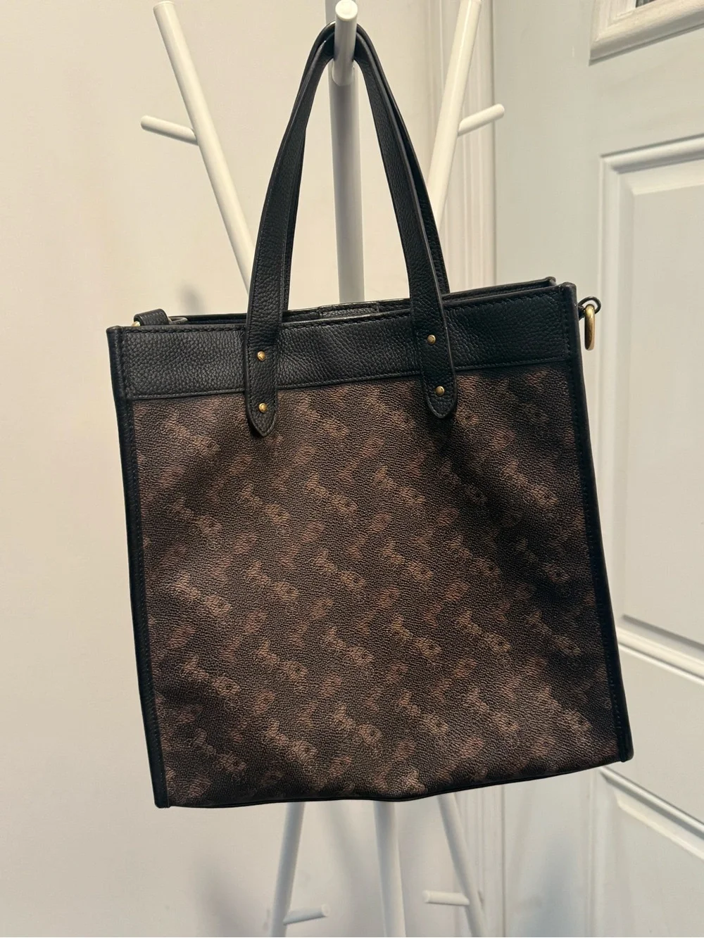 This is a Coach Field Tote in Truffle Black with a horse and carriage print